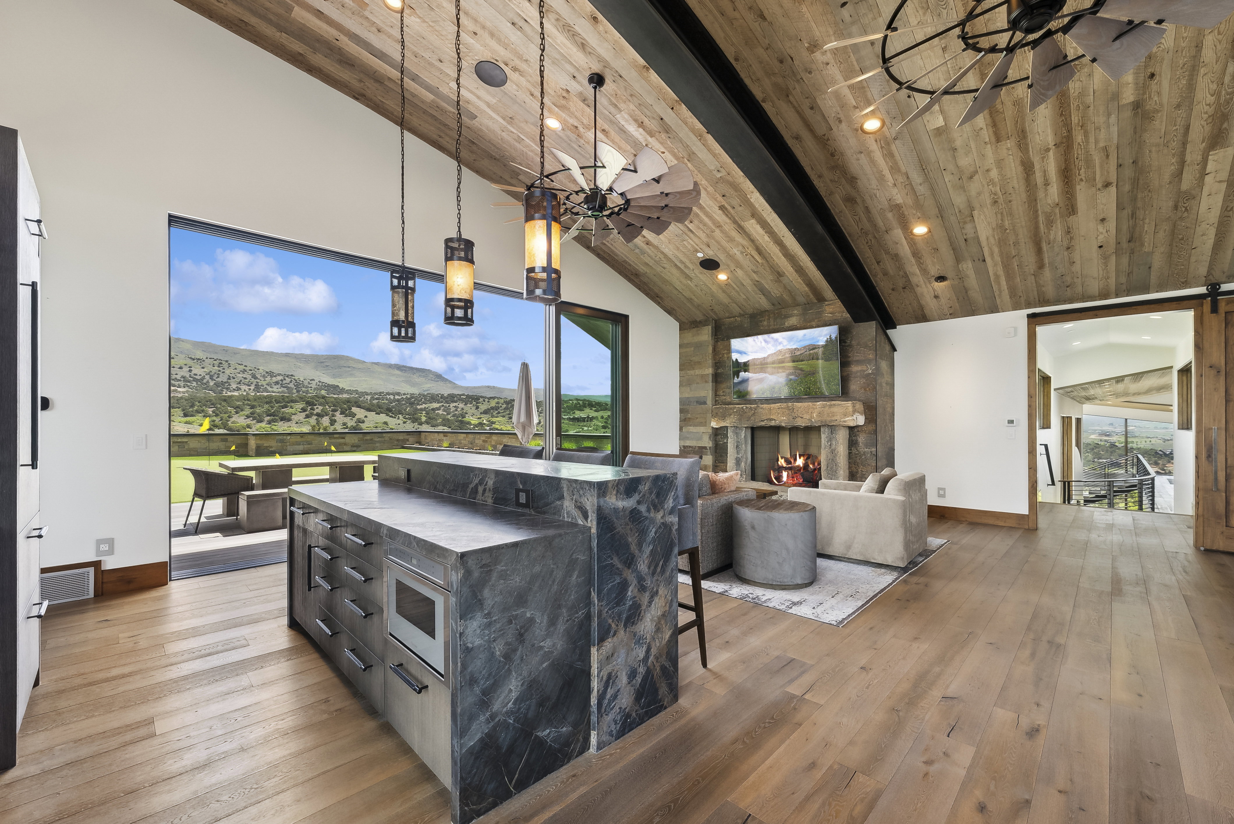 Open-concept living space with vaulted wood-plank ceilings and exposed beams