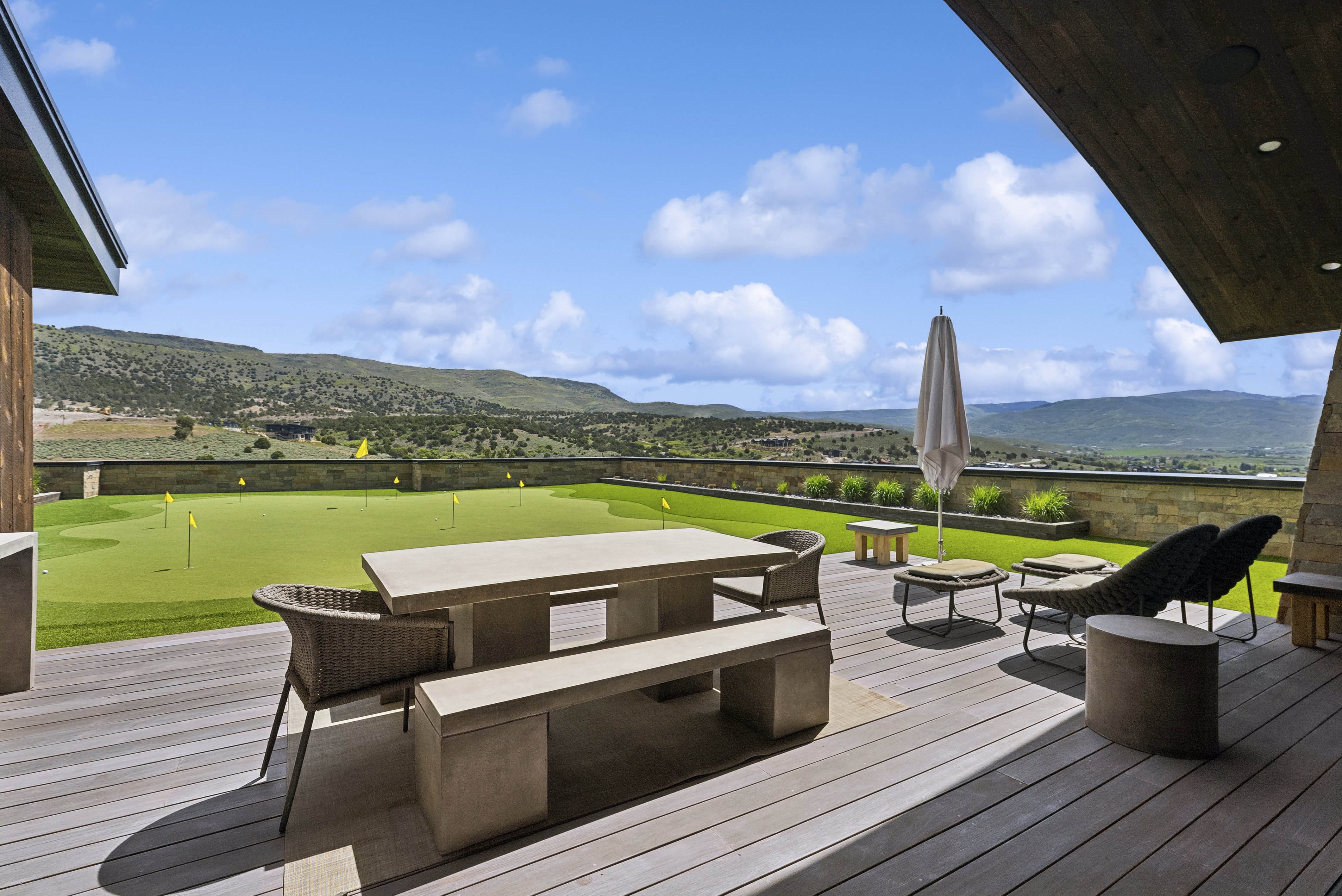 Expansive outdoor patio featuring composite decking and a built-in putting green