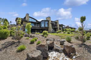 Contemporary architectural design featuring extensive stonework and dark wood siding