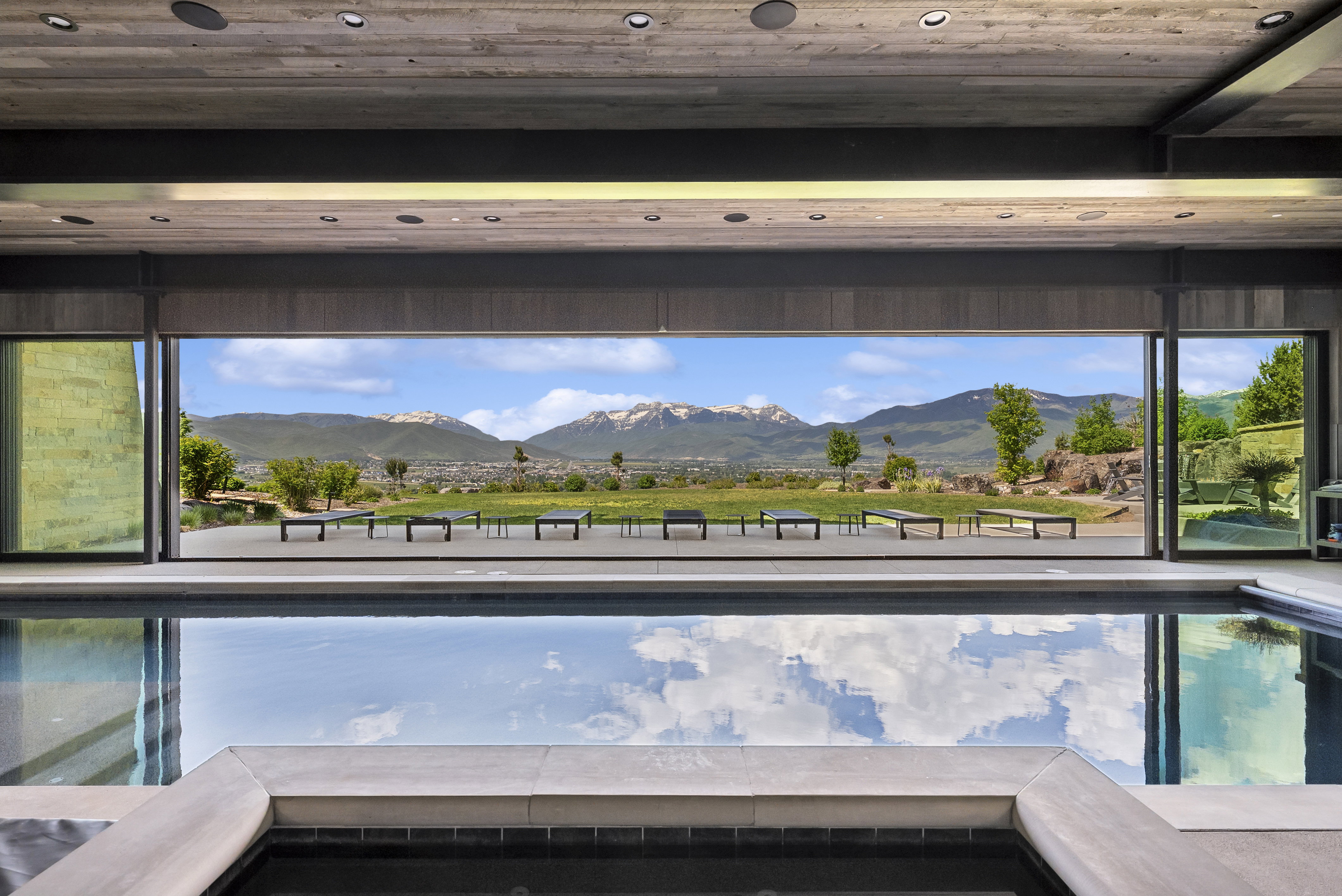 Indoor swimming pool with integrated spa, bordered by wide format porcelain tile coping