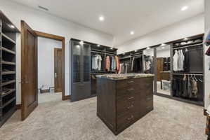Custom closet system featuring a central island with drawers and a stone countertop