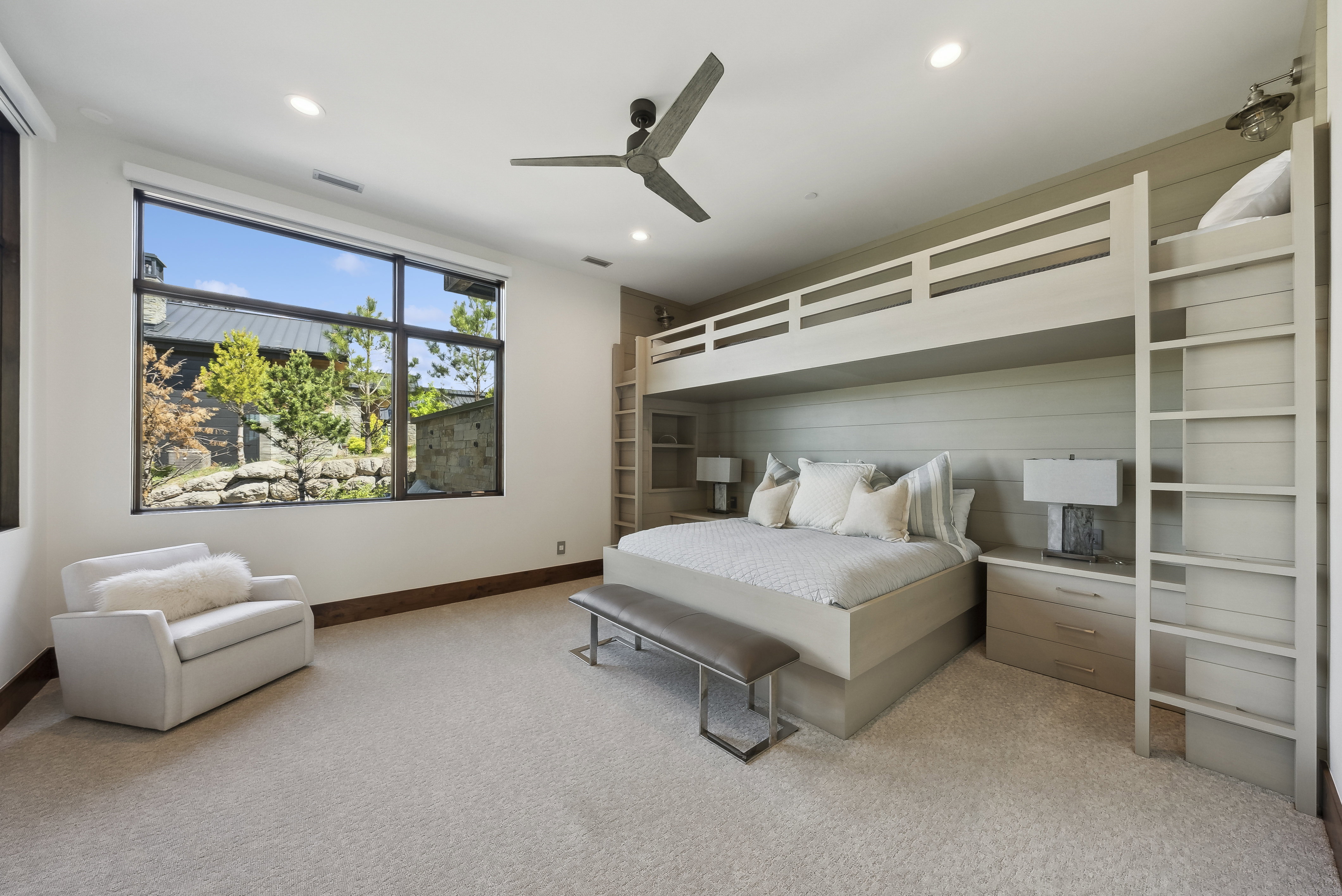 Spacious room featuring a full-wall window, built-in bunk beds, recessed lighting, and a modern ceiling fan