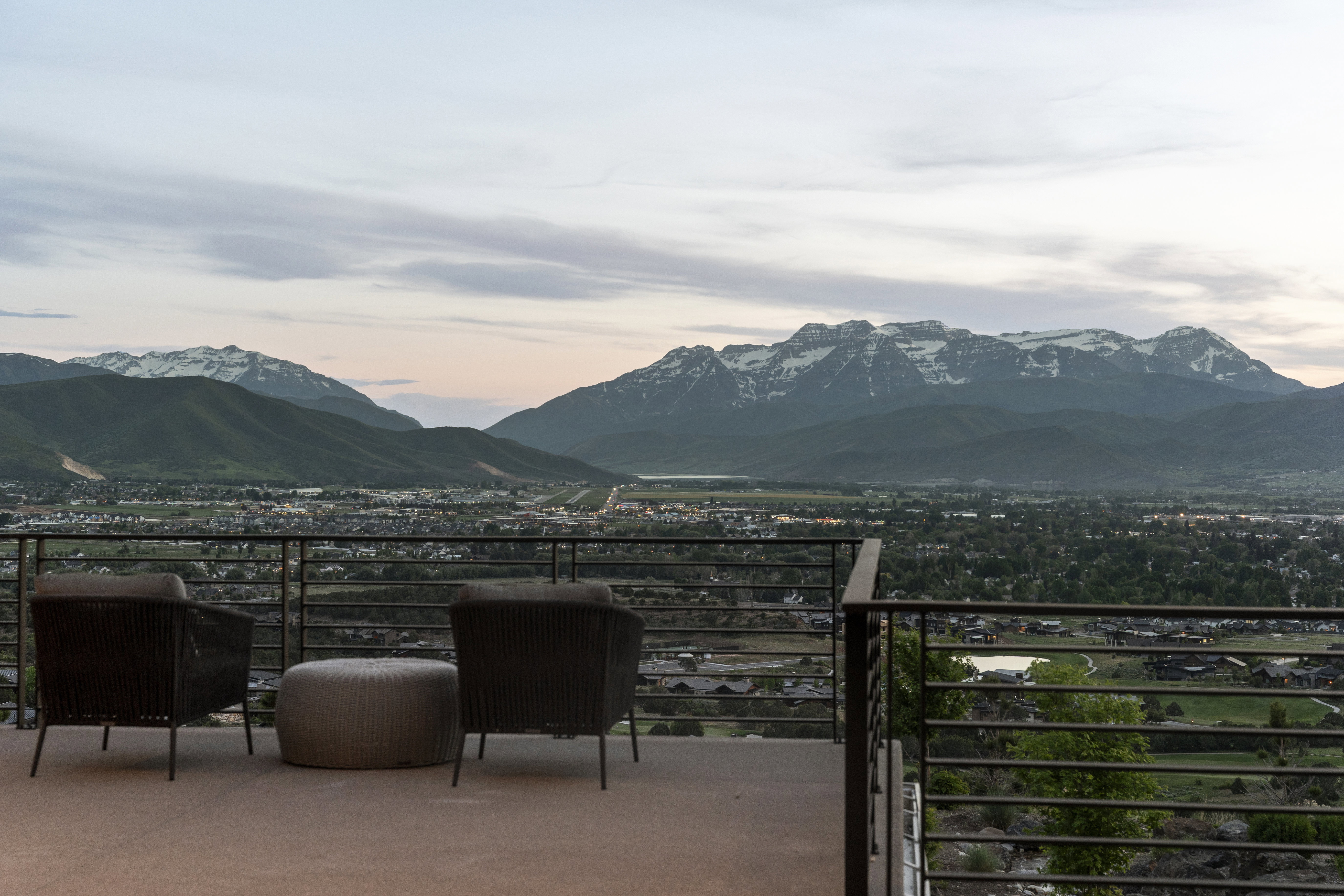 Expansive outdoor deck featuring a concrete surface and a metal horizontal railing system