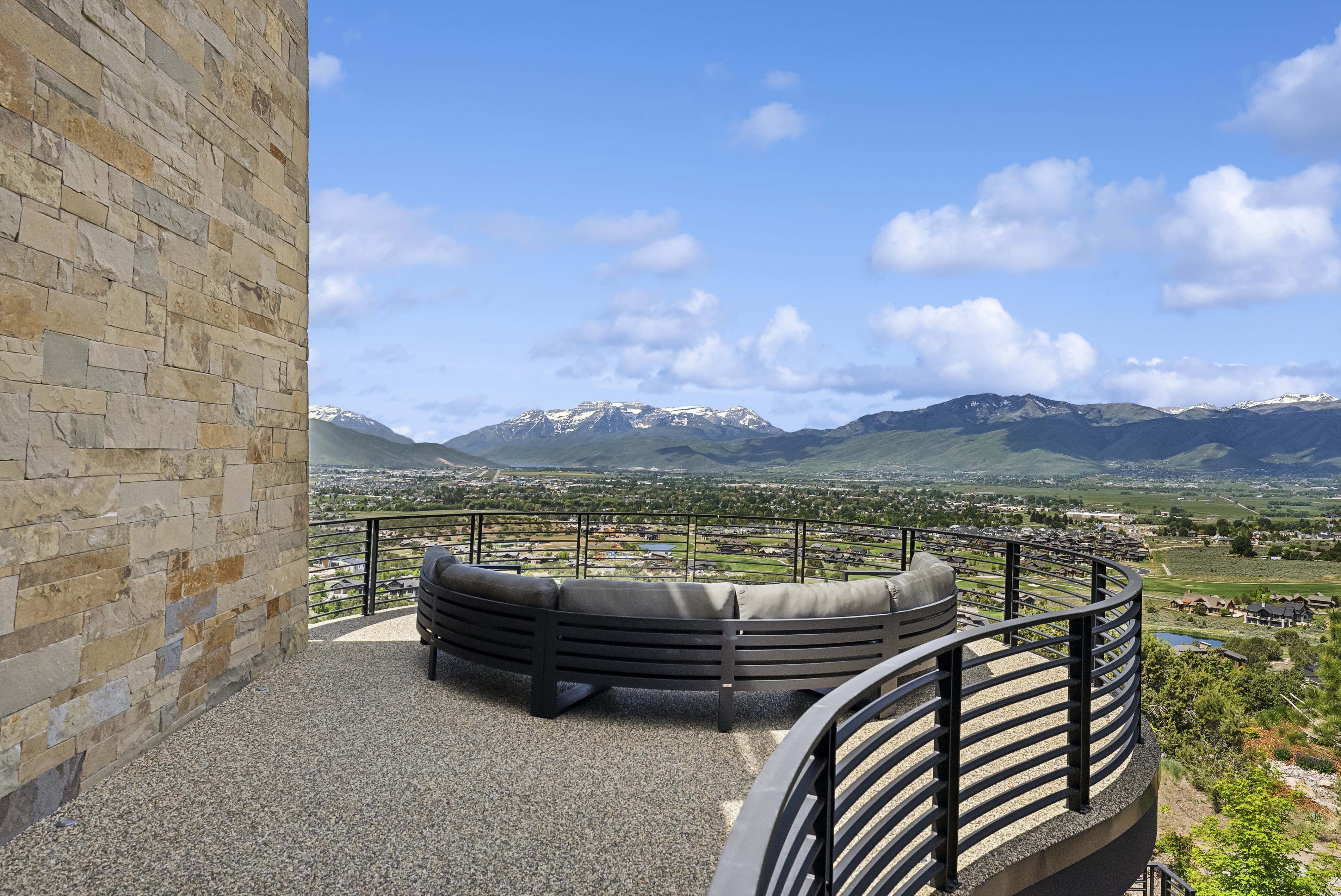 Spacious outdoor terrace with a stone veneer wall and a gravel-finish floor