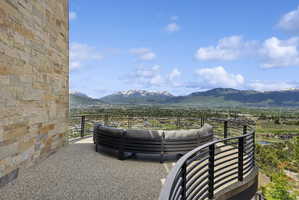 Spacious outdoor terrace with a stone veneer wall and a gravel-finish floor
