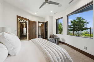 Spacious room featuring broad windows with mountain scenery, rich wood-finish doors, recessed lighting, a modern ceiling fan, and carpeted flooring