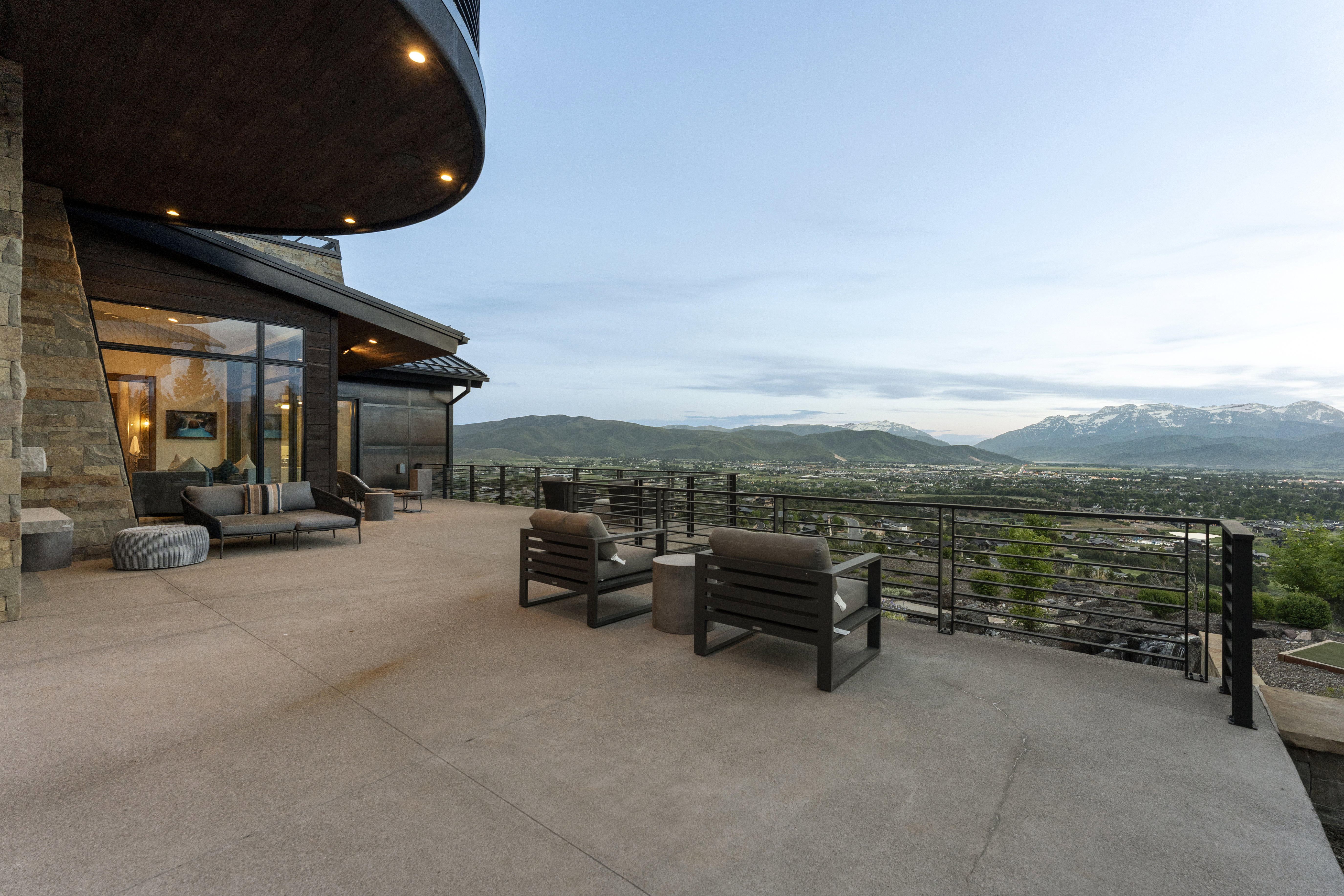 Expansive outdoor terrace with a concrete surface, featuring a modern cable railing system