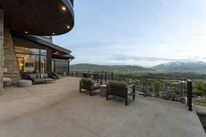 Expansive outdoor terrace with a concrete surface, featuring a modern cable railing system