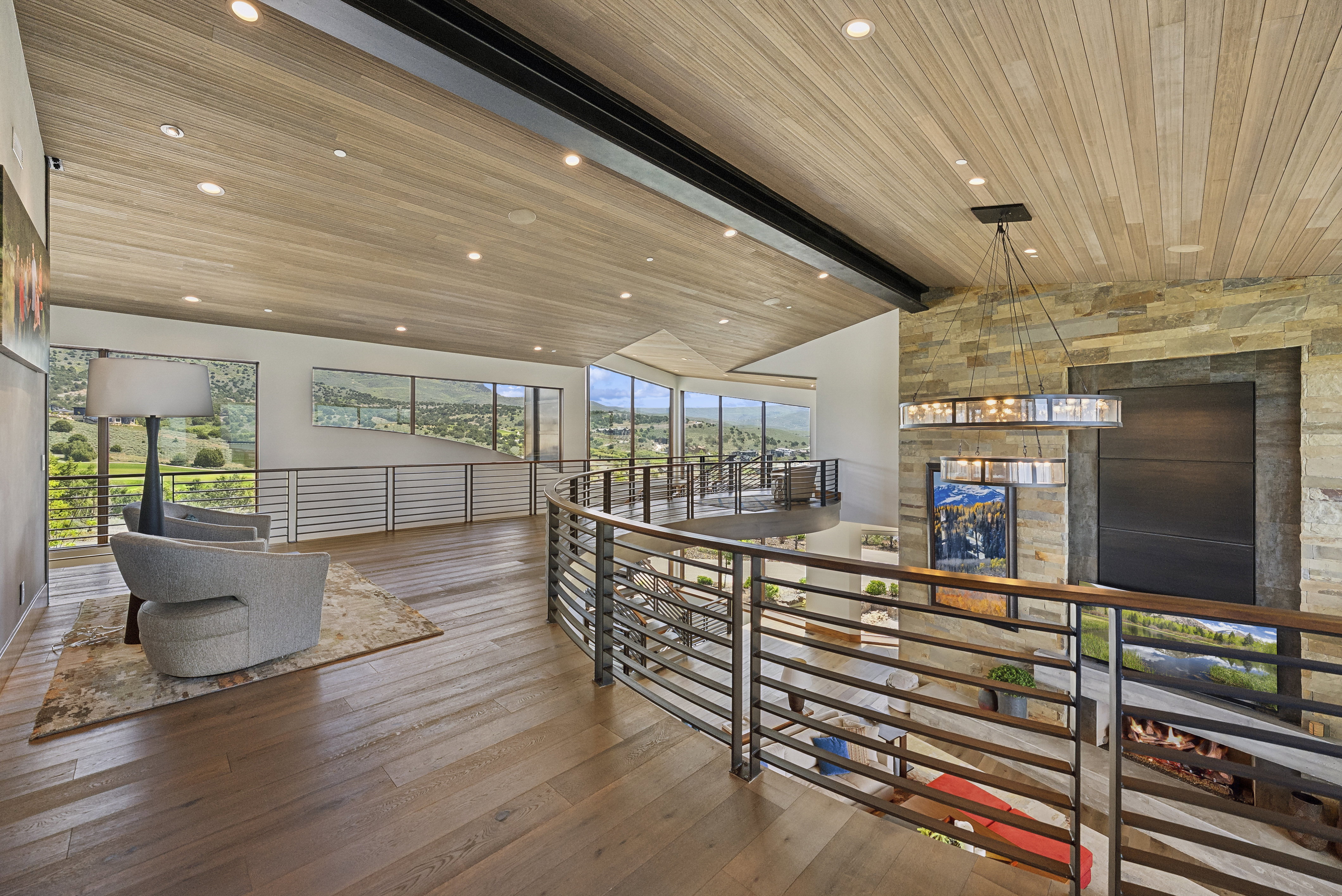 Open concept area featuring wood-finish flooring, a wood plank ceiling with recessed lighting, and a stone accent wall