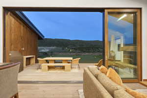 Expansive outdoor deck with wood-finish flooring, featuring a built-in stone countertop and a wood-paneled exterior wall