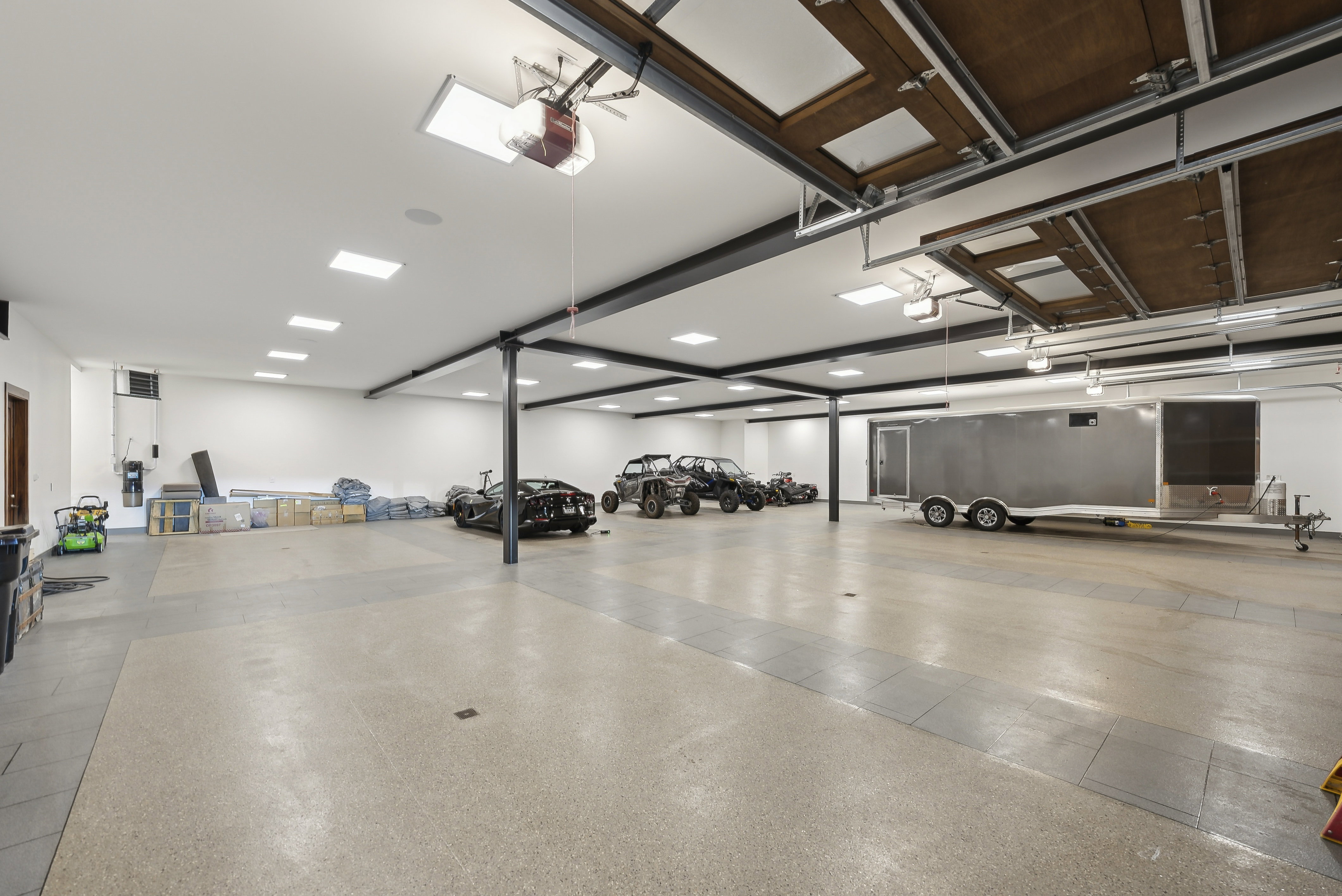 Expansive garage space featuring durable epoxy flooring and high ceilings with recessed lighting