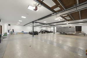 Expansive garage space featuring durable epoxy flooring and high ceilings with recessed lighting