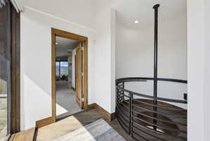 Curved staircase featuring a wrought iron railing and wood-finish treads
