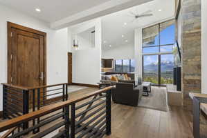 Open-concept living space with vaulted ceilings, a stone accent wall, and expansive windows offering mountain scenery