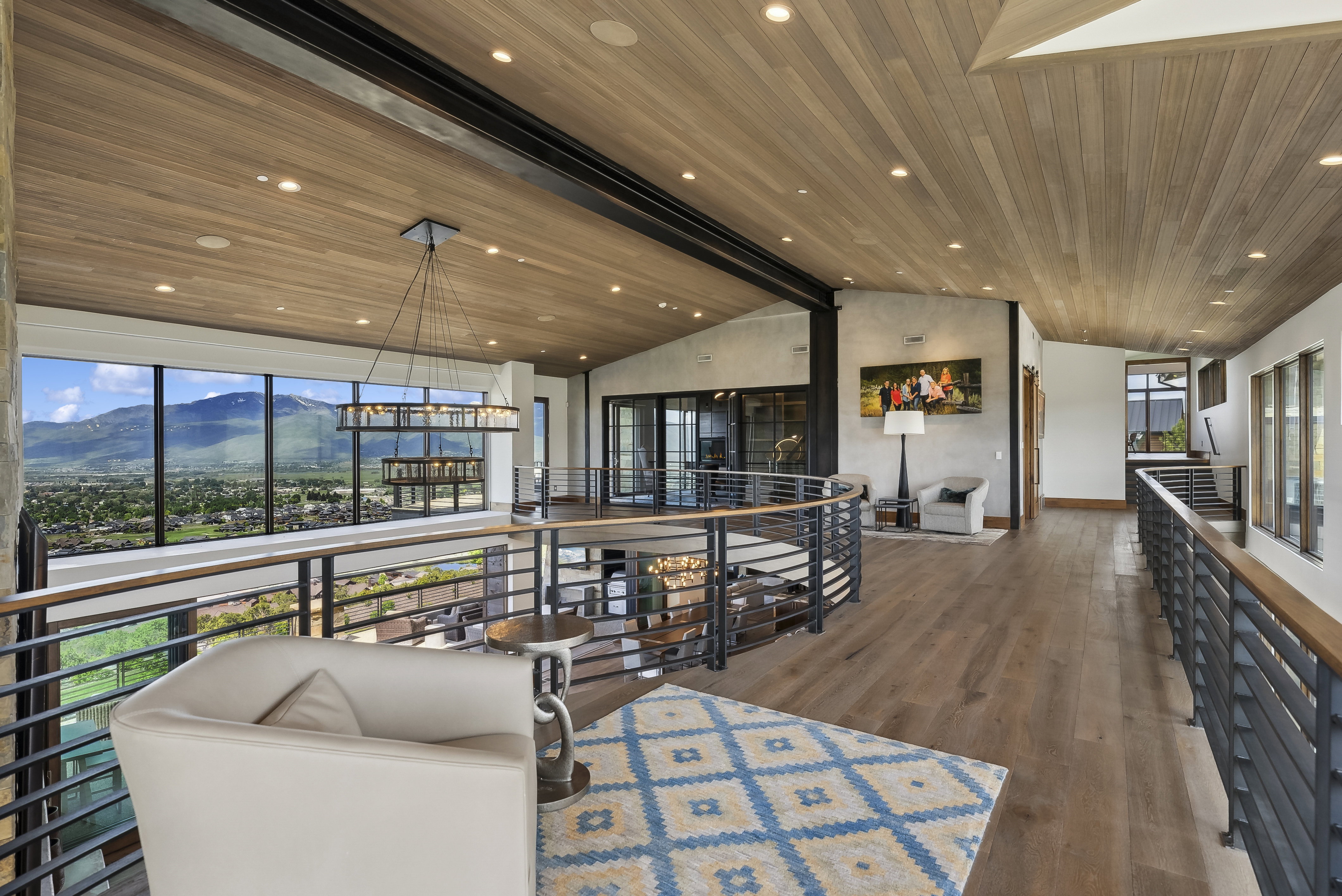 Upper level hallway featuring wood-finish flooring, a wood-paneled ceiling with recessed lighting, and a contemporary chandelier