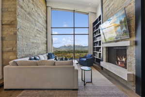 Two-story living area featuring a stone accent wall and a floor-to-ceiling window