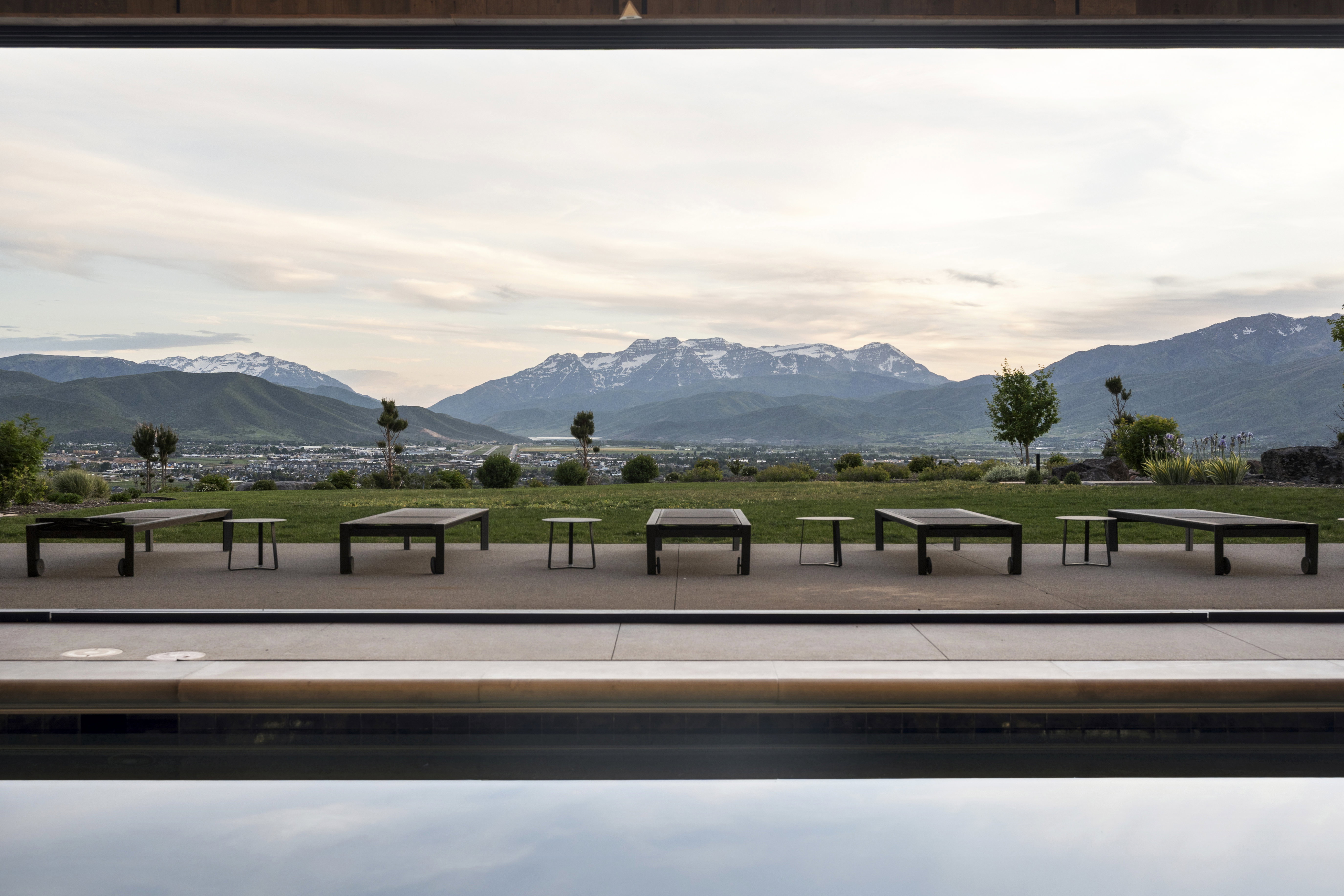 Infinity-edge pool overlooking a expansive landscape with distant mountains