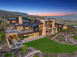 Expansive residence featuring multiple outdoor patios, a rectangular pool, and a manicured lawn