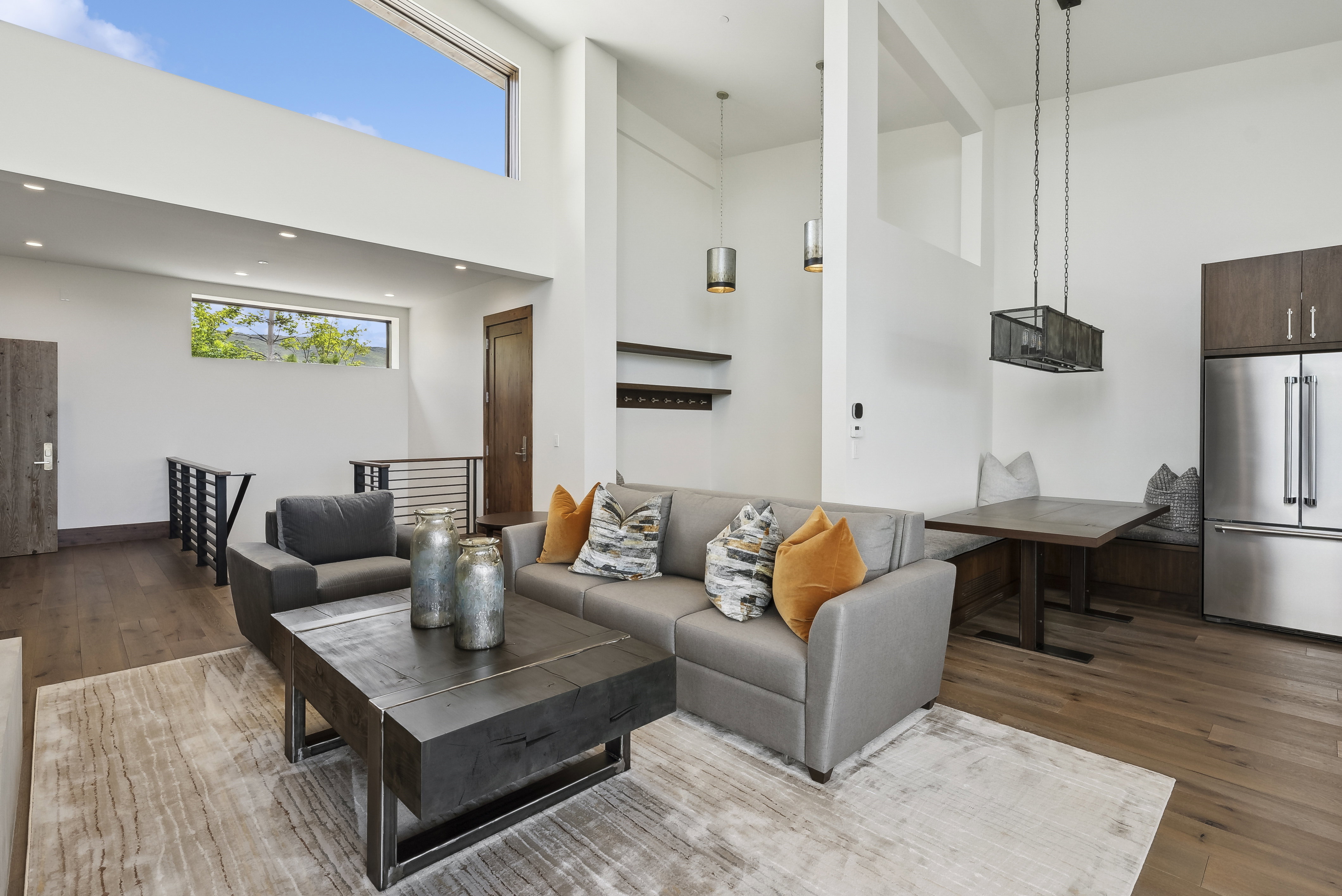 Open-concept living area featuring high ceilings, wood-finish flooring, and recessed lighting