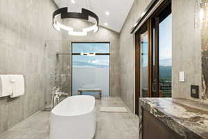 Contemporary bathroom featuring a freestanding soaking tub, glass-enclosed shower, and a dramatic vaulted ceiling with a modern chandelier