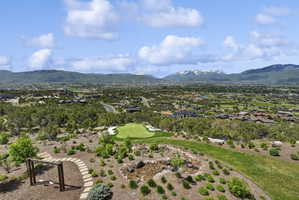 Expansive hillside property featuring a private putting green, a stone path, and a wooden swing set