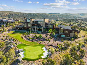 Modern architectural residence featuring extensive glazing, stone, and wood siding