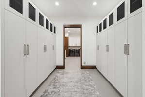 Hallway with extensive built-in cabinetry featuring sleek white doors and contemporary hardware