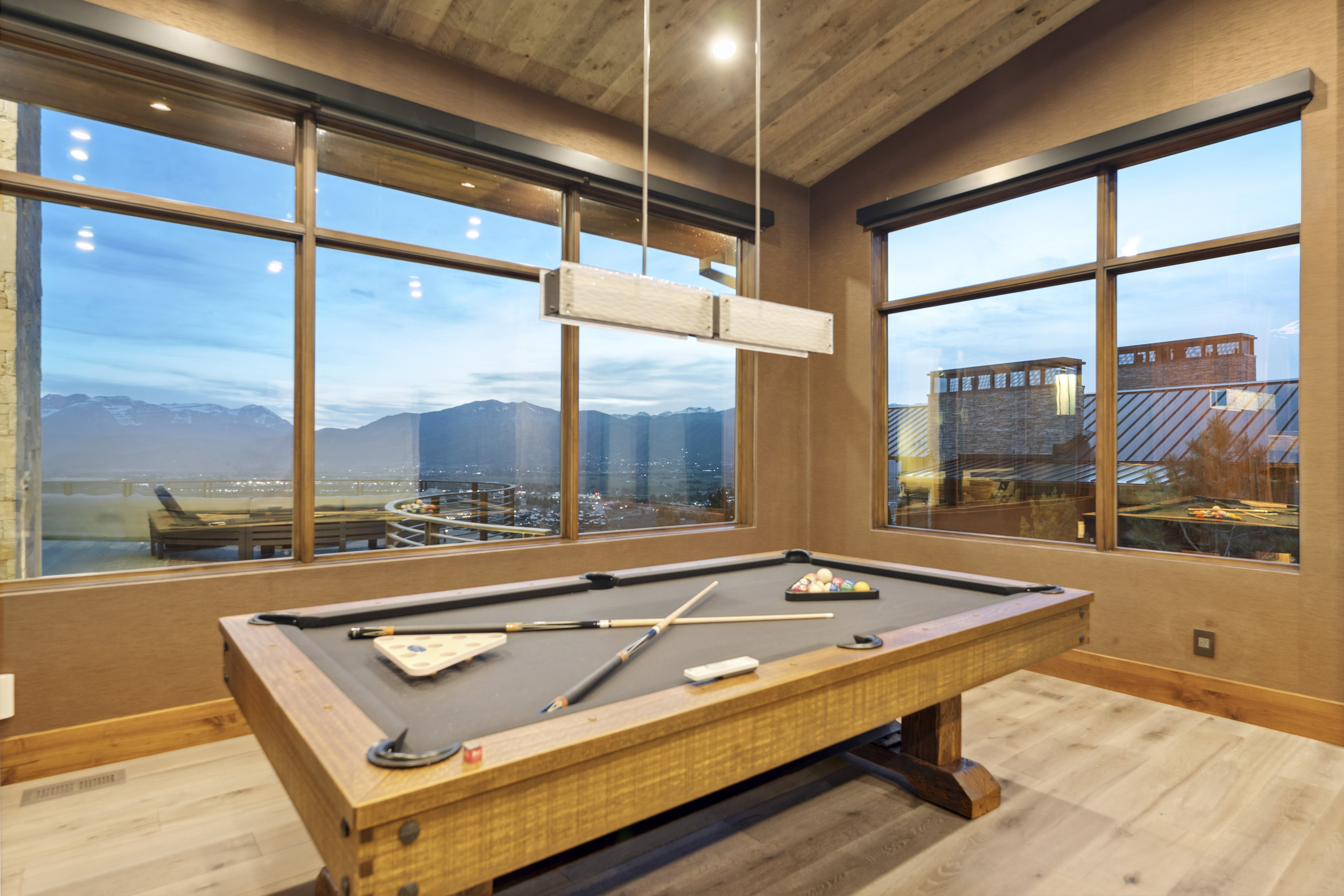 Spacious room featuring floor-to-ceiling windows, light wood-finish flooring, and a vaulted wood-paneled ceiling