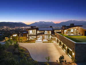 Contemporary architectural design featuring extensive glazing, a multi-car garage, and a rooftop putting green