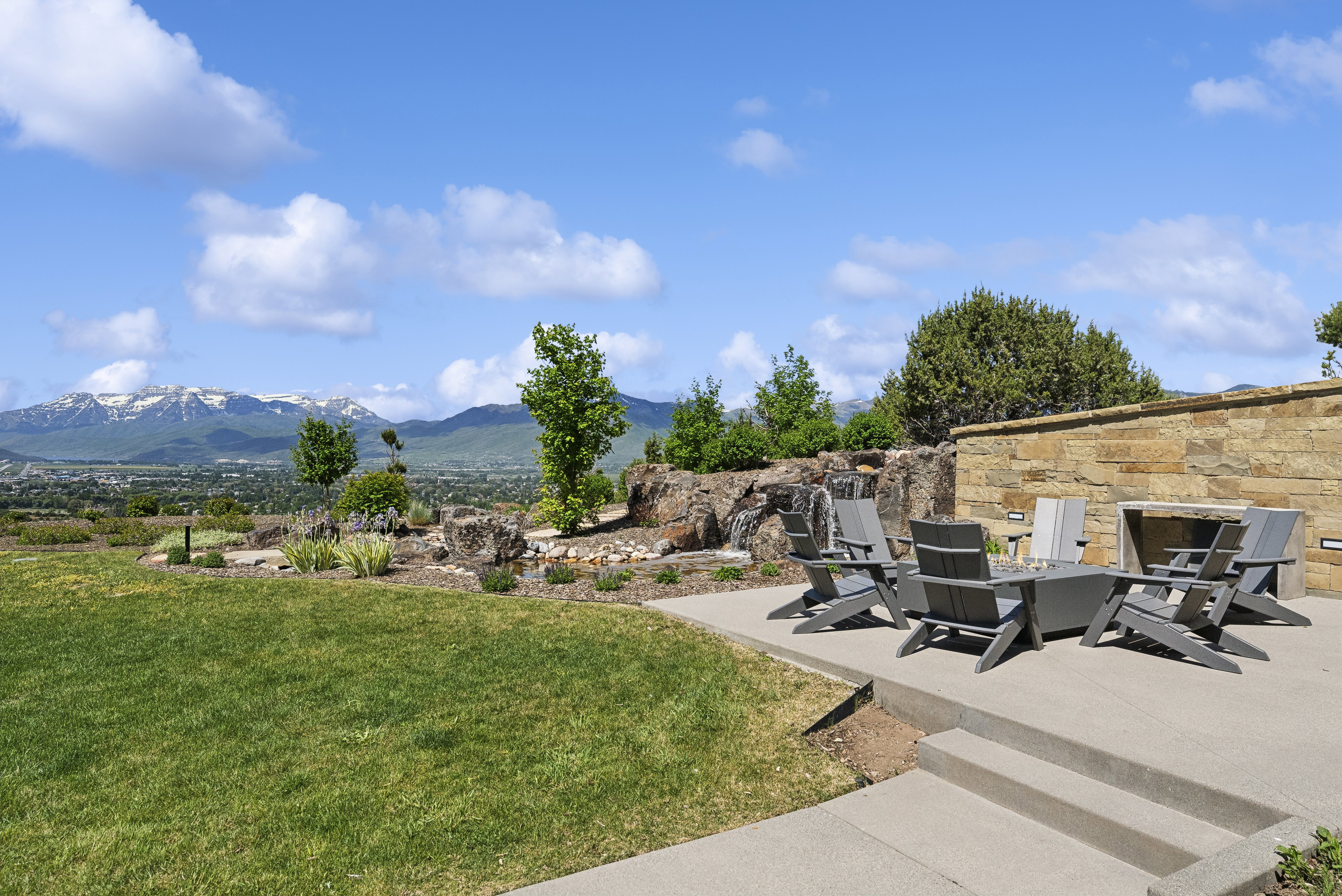 Expansive outdoor patio with a built-in stone fireplace and a concrete surface