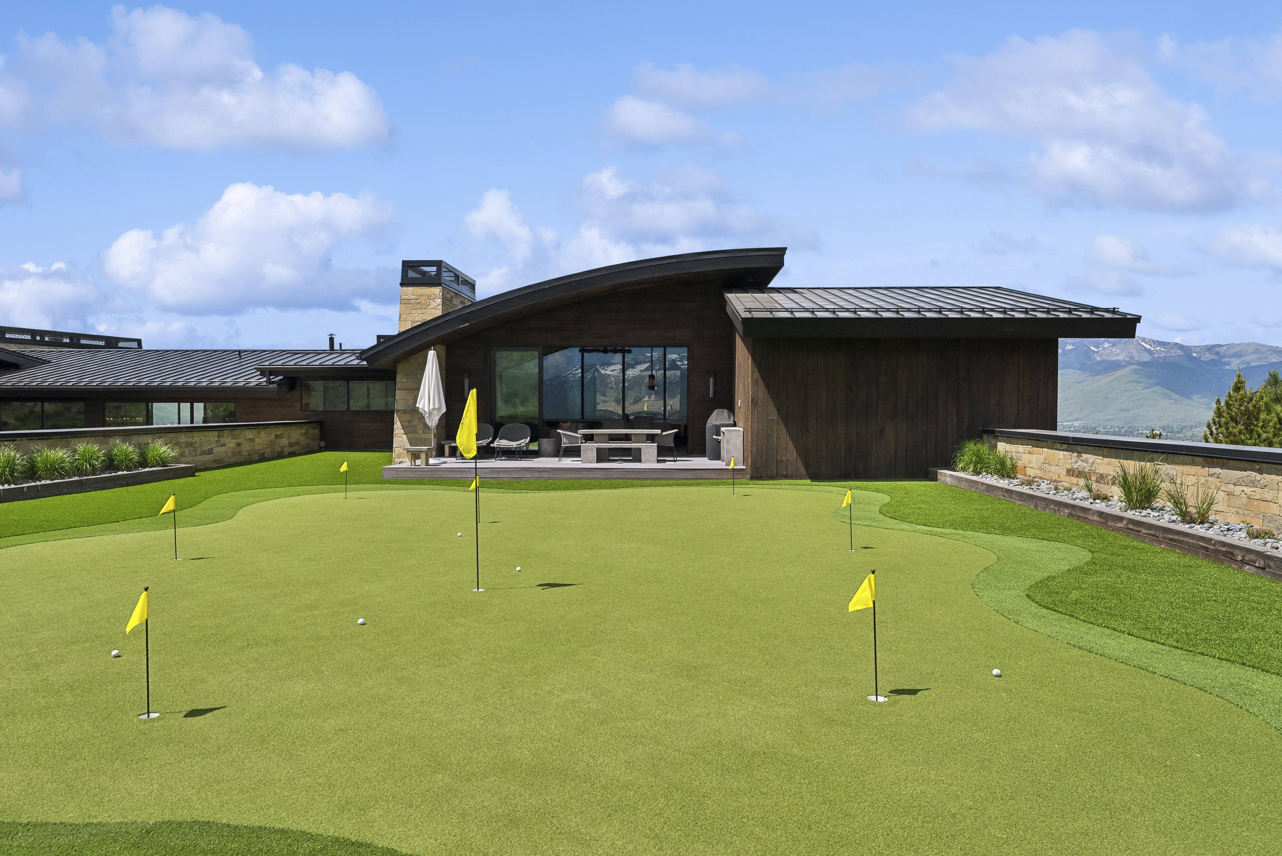 Putting green featuring multiple holes and yellow flags