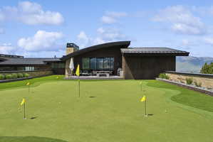 Putting green featuring multiple holes and yellow flags