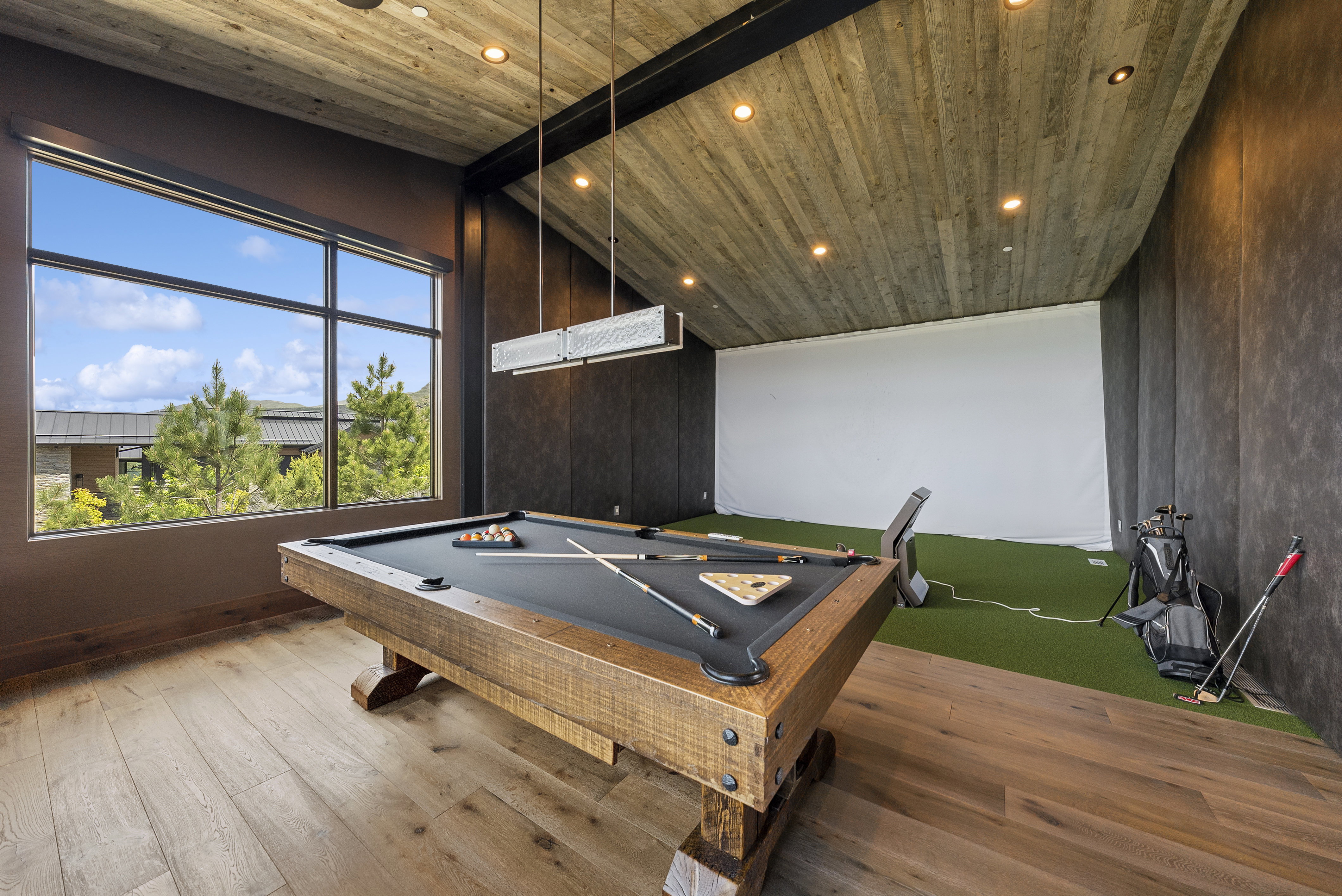 Recreation room featuring wood-finish flooring, a wood-paneled ceiling with recessed lighting, and a large window