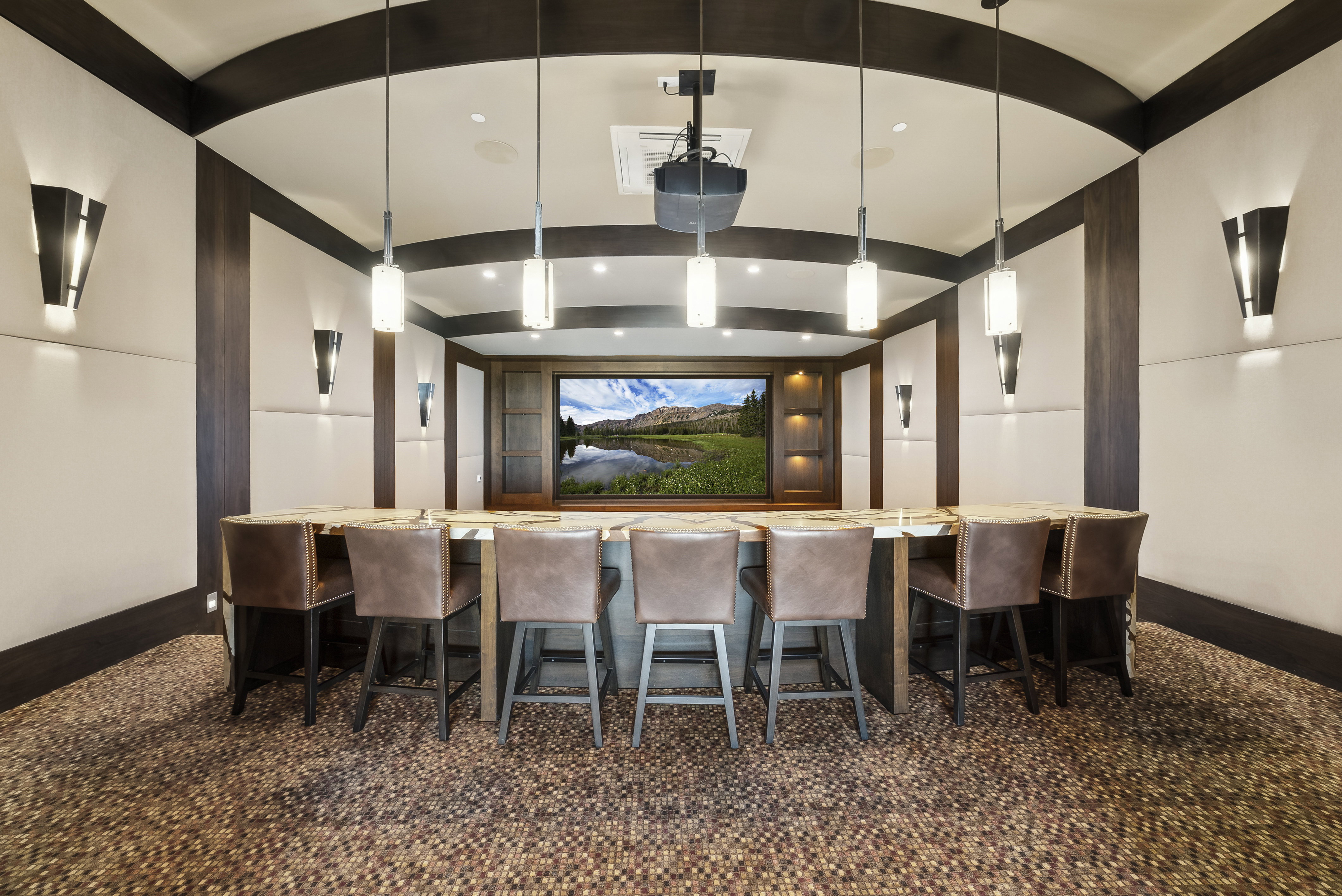 Dedicated media room featuring a large screen display, recessed lighting, and a projector
