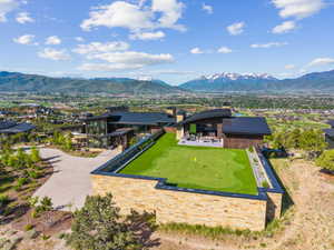 Modern architectural residence featuring a stone-clad exterior and dark rooflines