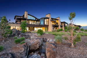 Contemporary multi-level residence featuring stone and wood siding, extensive glazing, and multiple outdoor terraces
