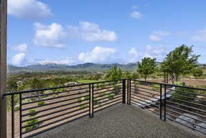 Expansive outdoor balcony featuring a speckled aggregate floor and horizontal metal railing