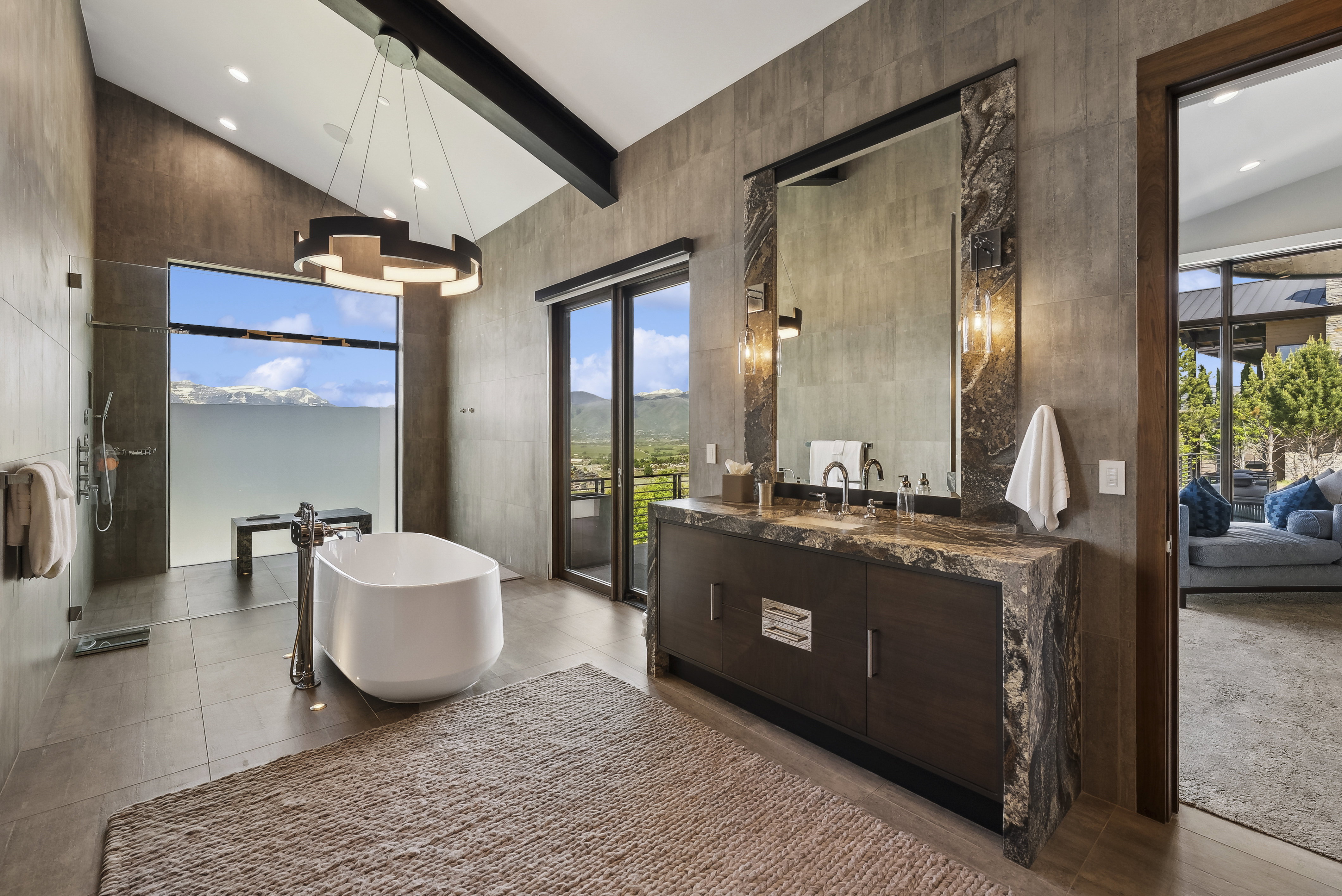 Spacious bathroom featuring a freestanding soaking tub, walk-in shower with glass enclosure, and a double vanity with stone countertops