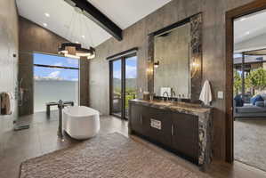 Spacious bathroom featuring a freestanding soaking tub, walk-in shower with glass enclosure, and a double vanity with stone countertops