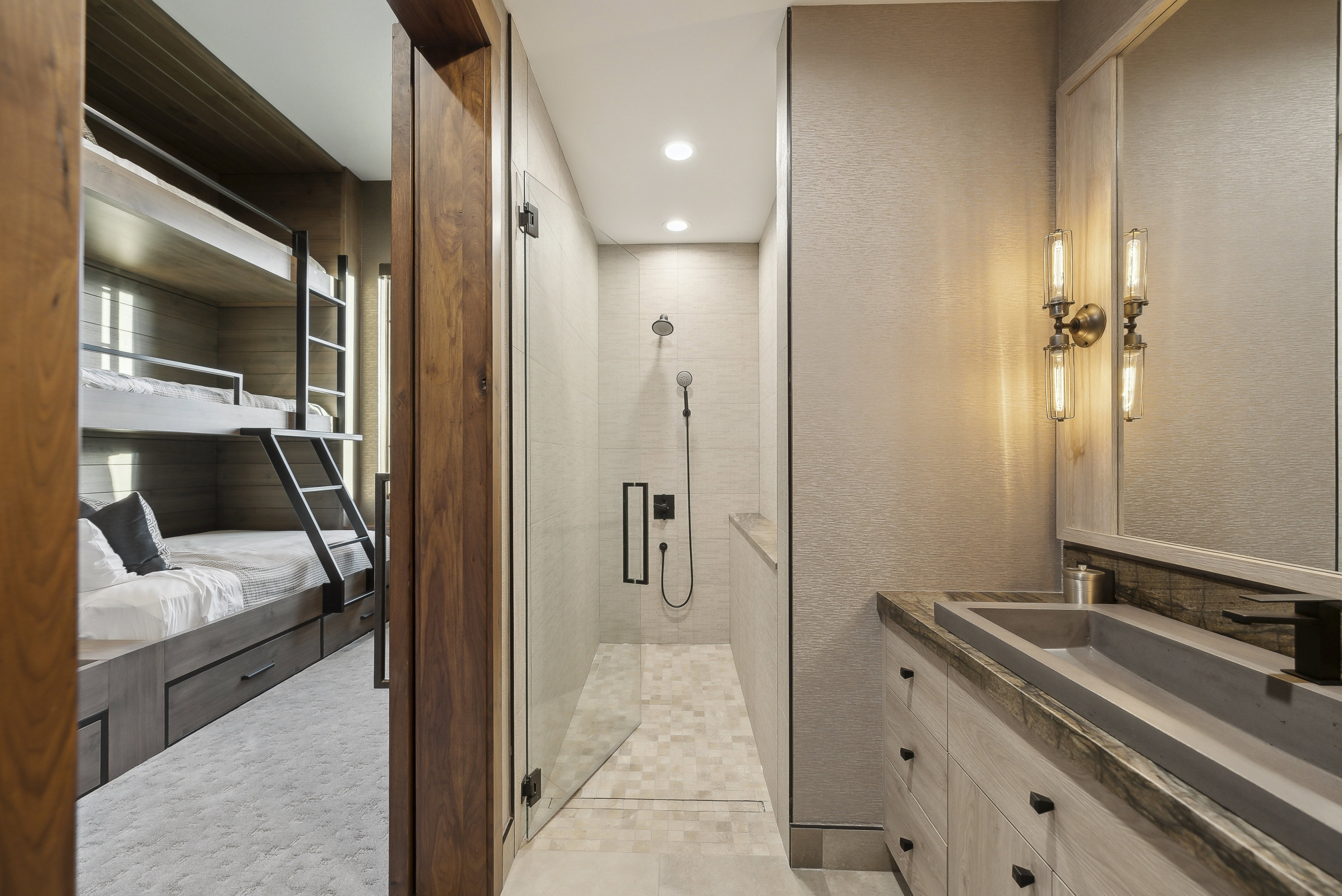 Bathroom with a contemporary vanity featuring a concrete vessel sink and a wall-mounted faucet