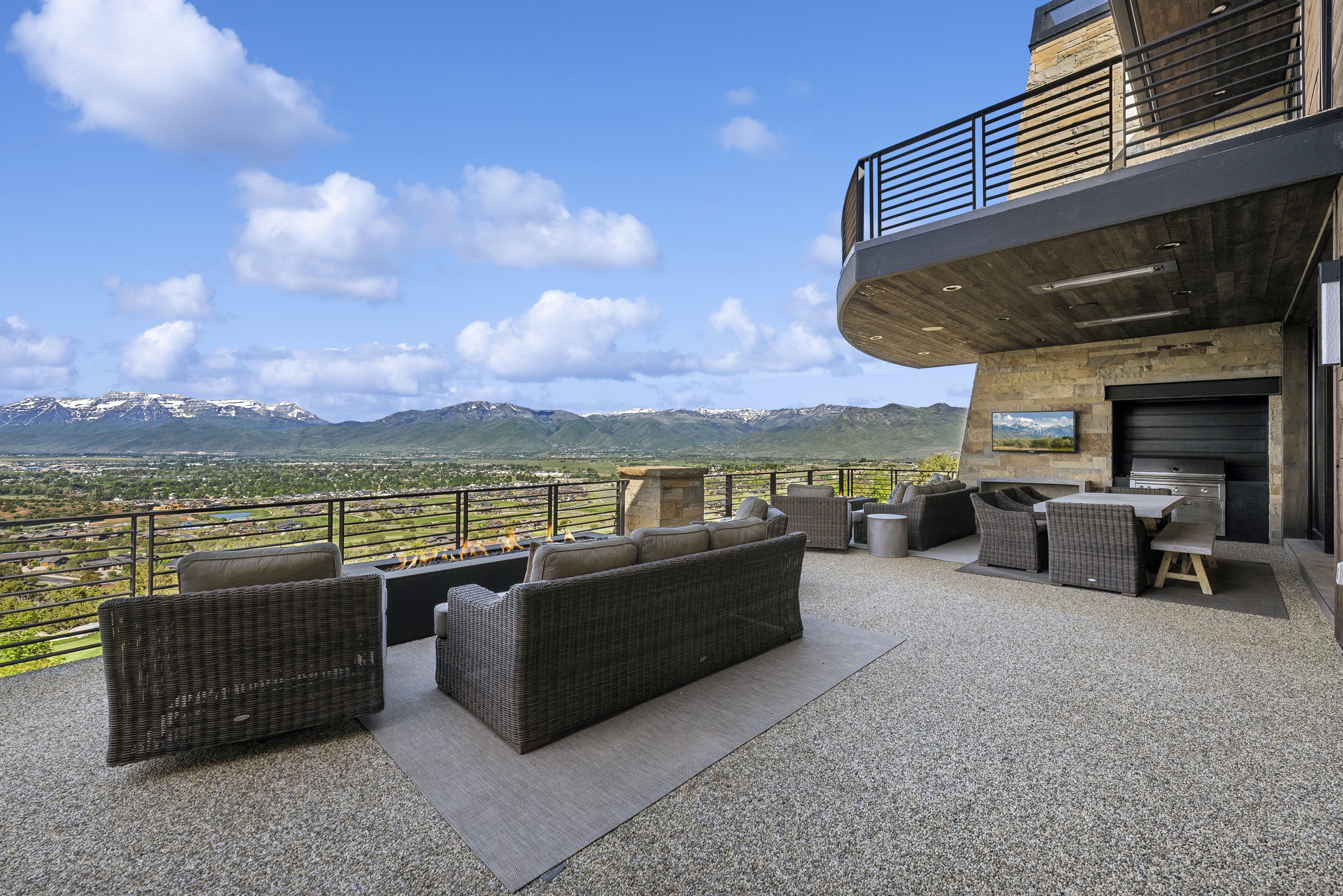 Spacious outdoor terrace with a concrete aggregate surface and a built-in linear fire pit
