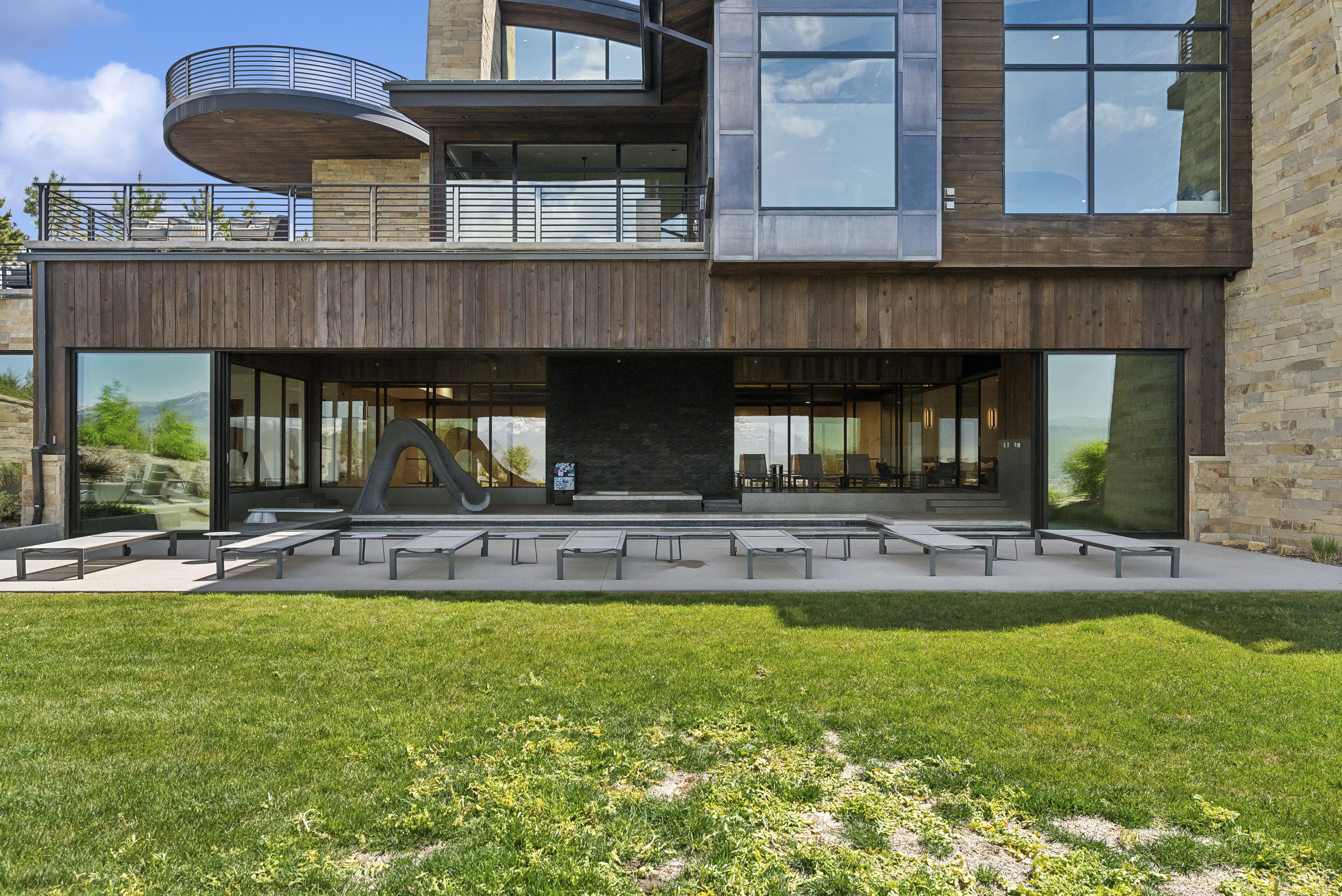 Multi-level modern exterior featuring natural wood siding and stone accents