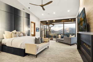 Spacious bedroom featuring floor-to-ceiling windows, a linear fireplace, and a contemporary ceiling fan