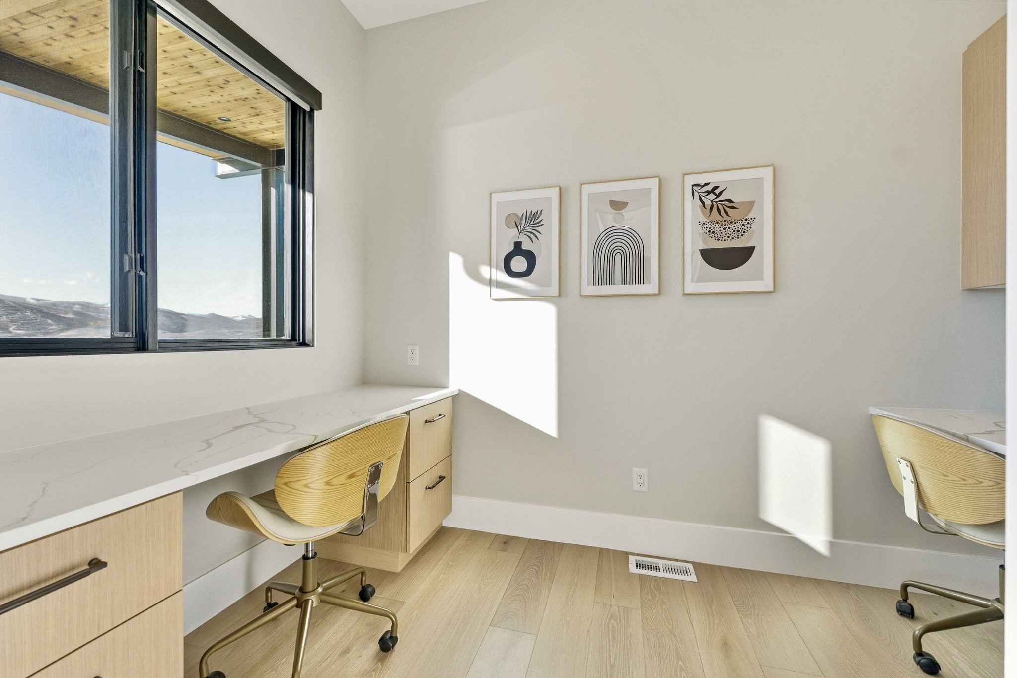 Built-in desk featuring a white countertop and light wood-finish cabinetry