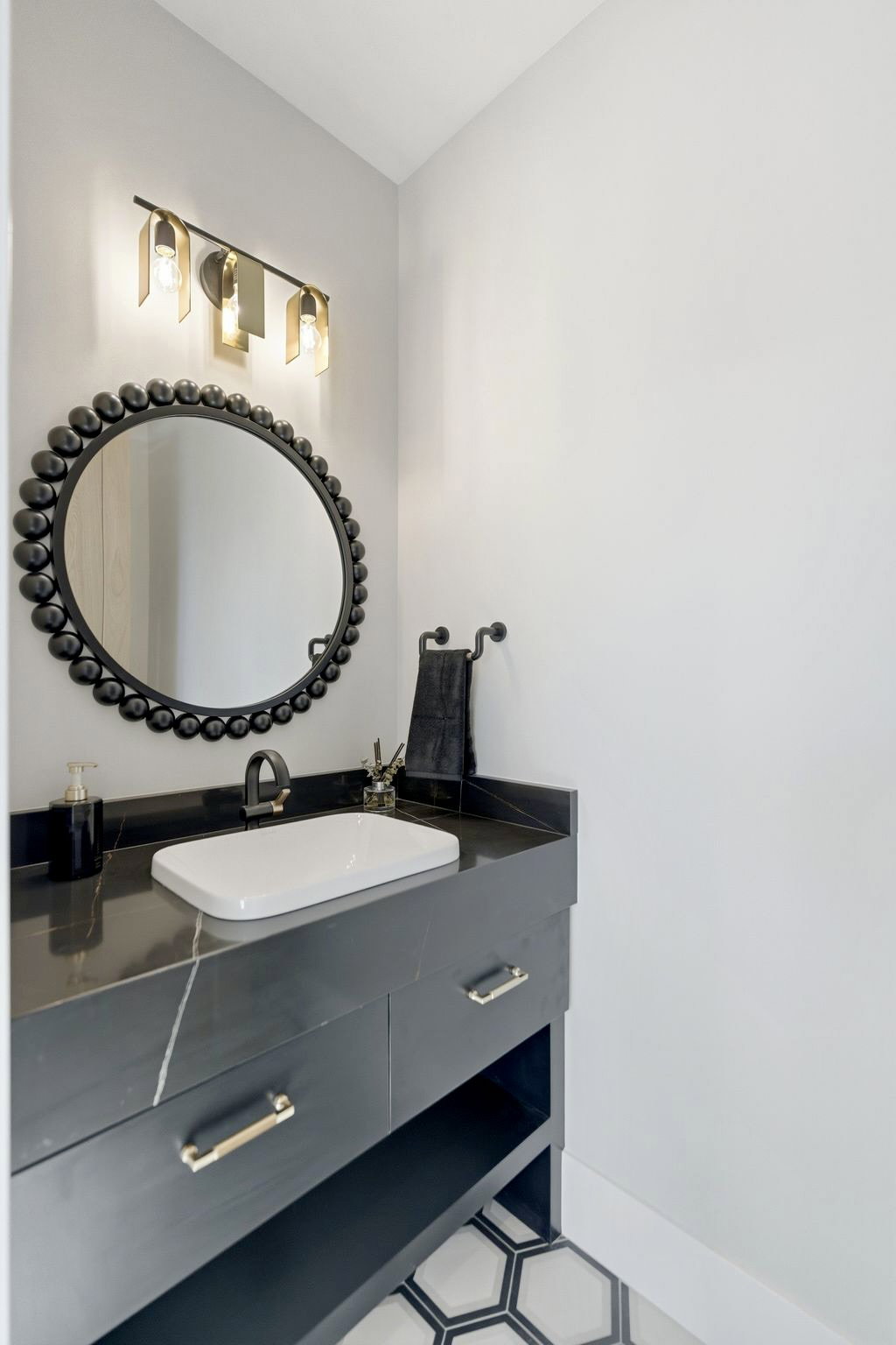 Vanity featuring a black countertop with white veining, a rectangular vessel sink, and a matte black faucet