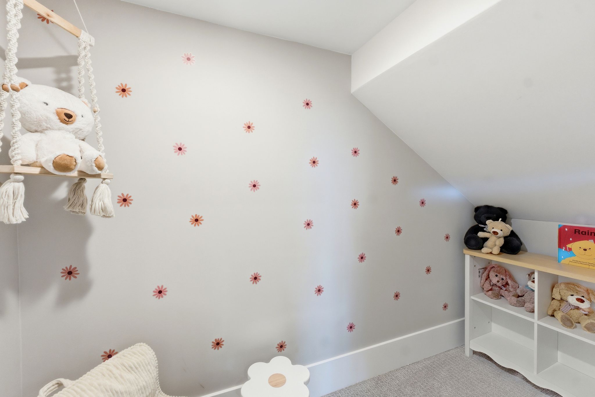 Room featuring a sloped ceiling, light-colored wall with decorative elements, and wall-to-wall carpeting
