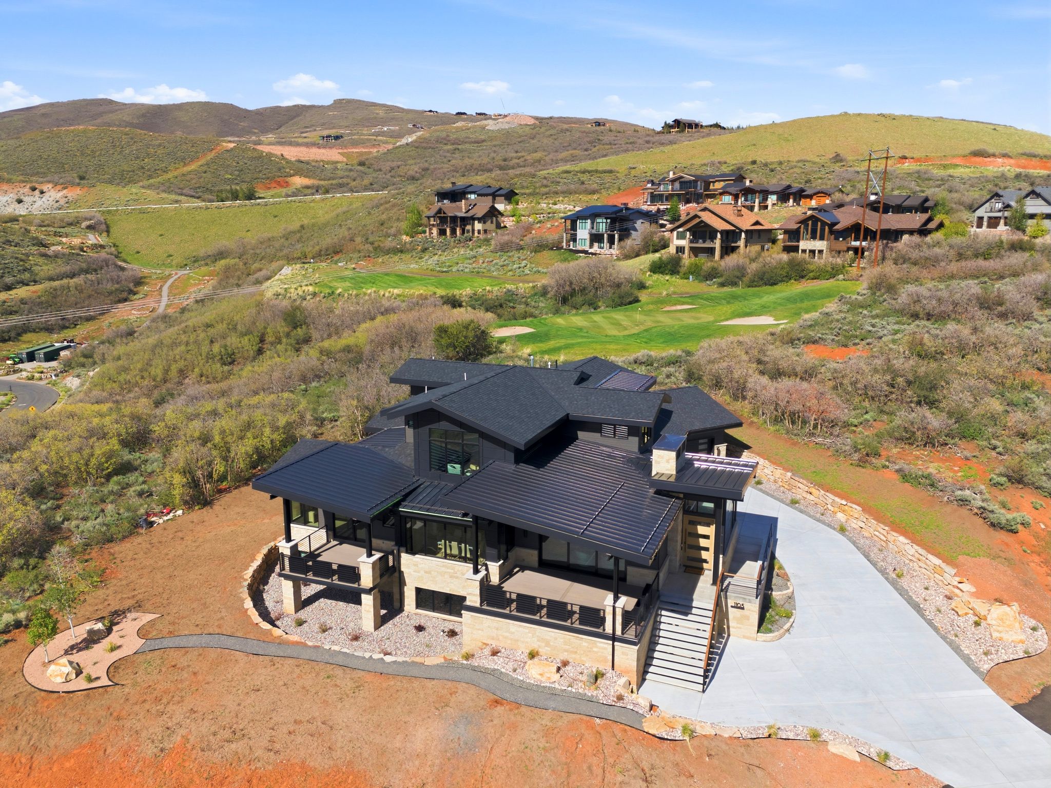 Modern residence featuring a multi-level design with stone facade accents and dark paneling