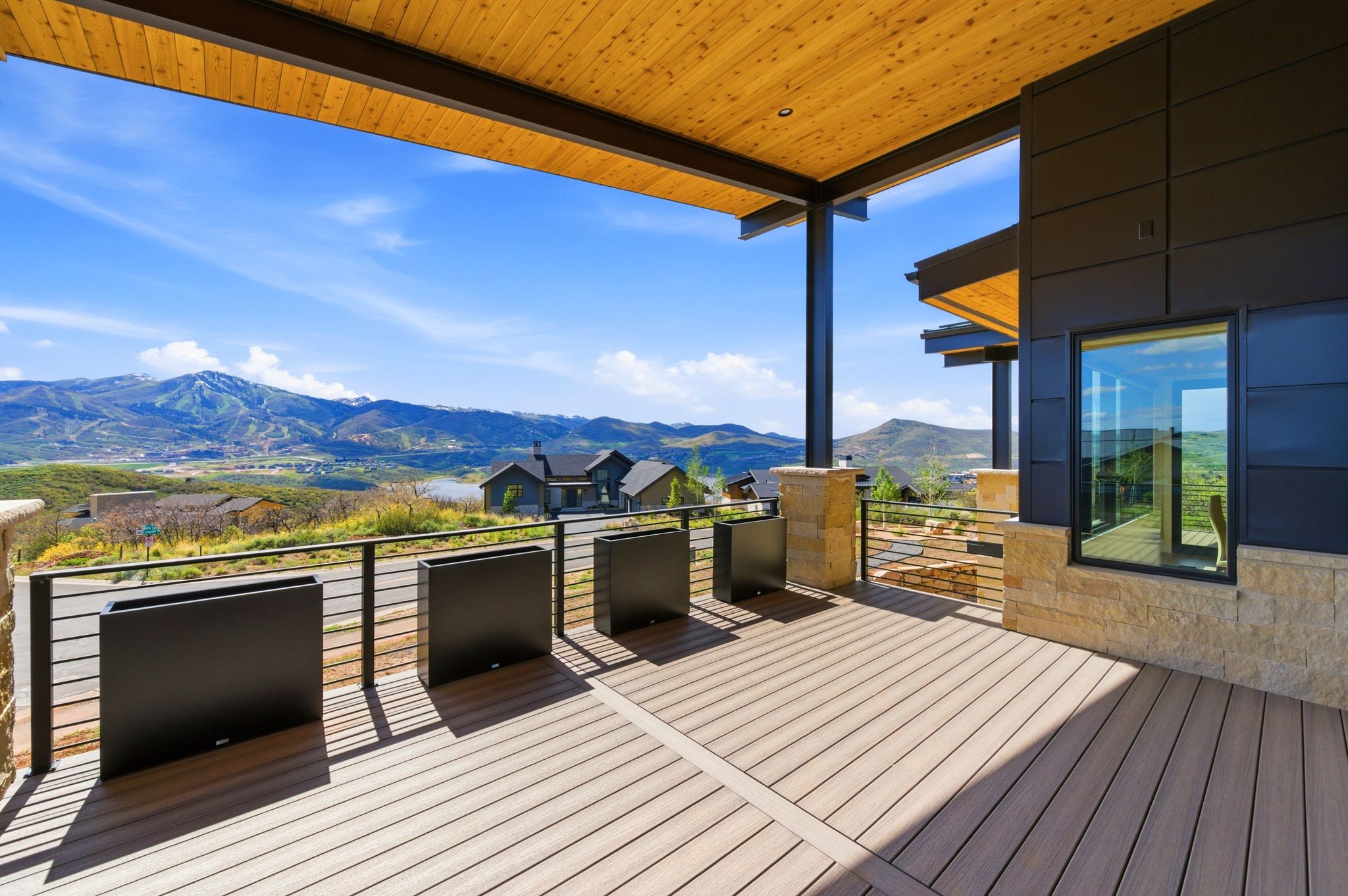 Expansive deck featuring composite flooring, a cable railing system, and a wood-paneled ceiling