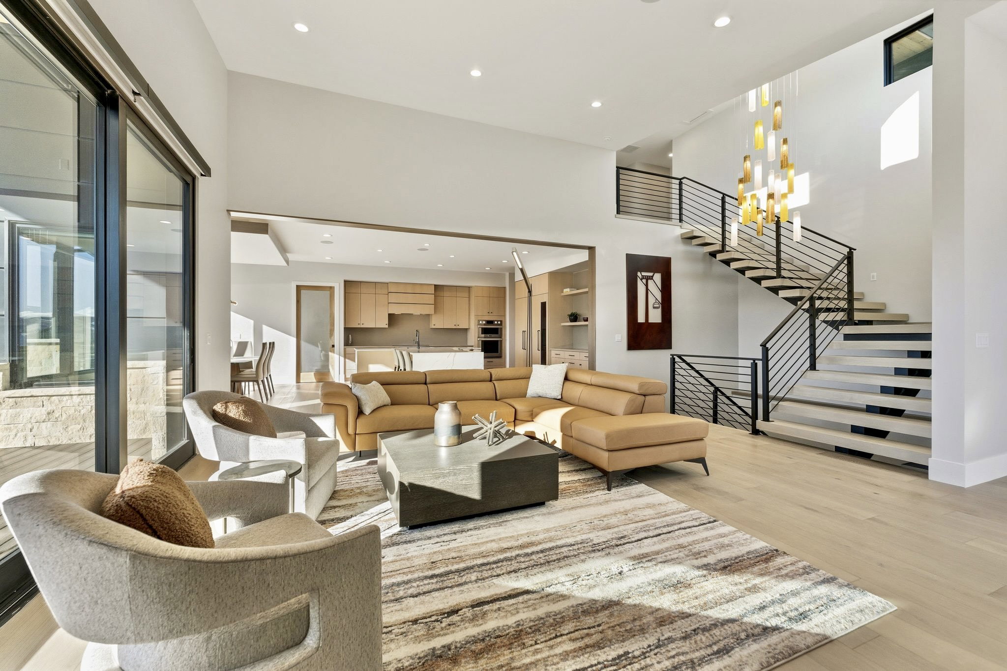 Spacious living area featuring a vaulted ceiling and light wood-finish flooring