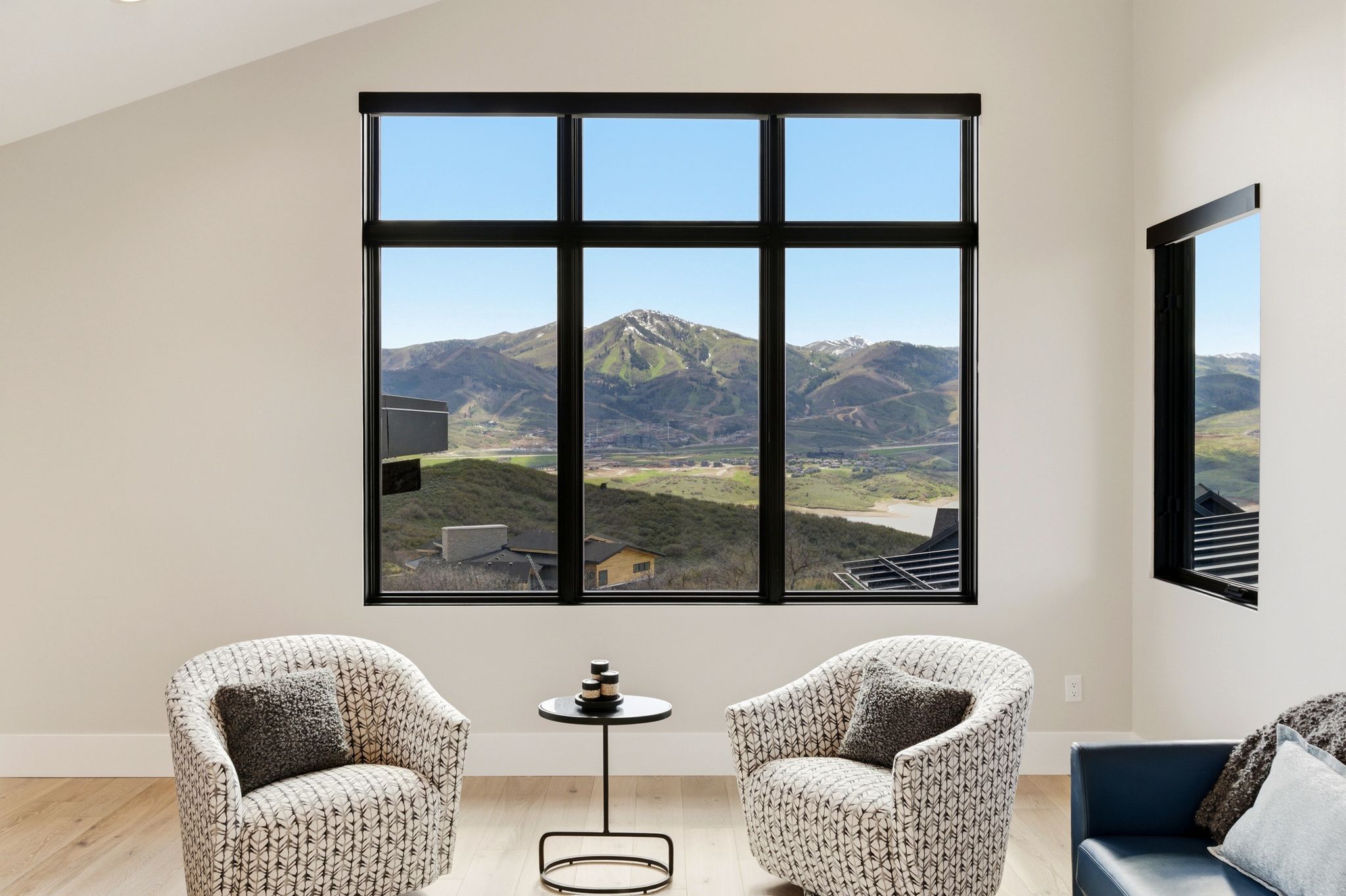Expansive black-framed window showcasing mountain scenery